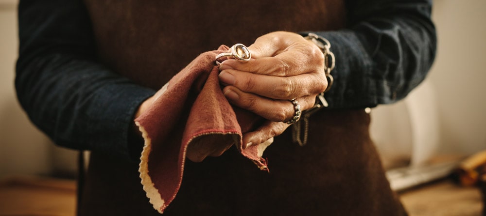 hands polishing a ring with a rag