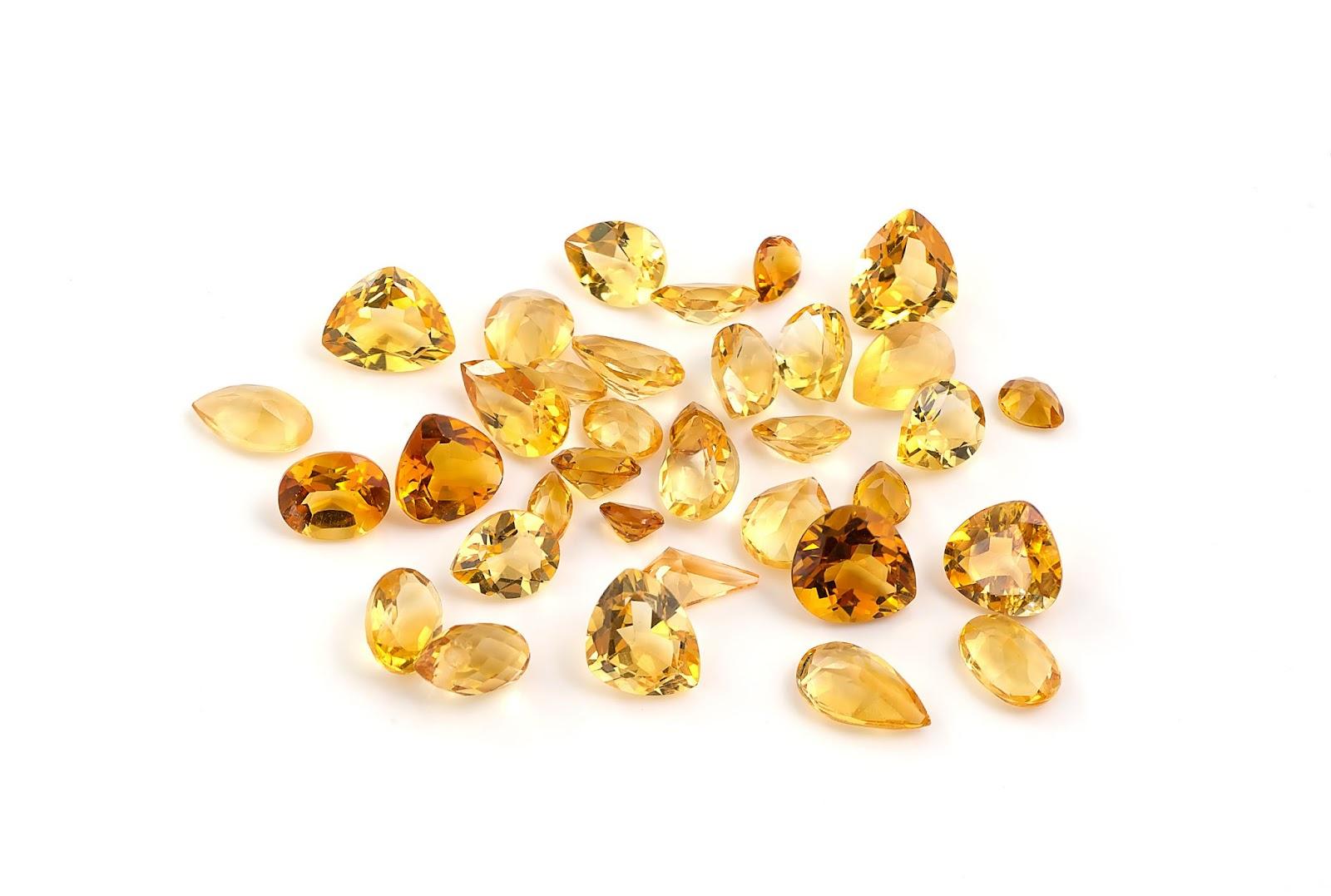 A collection of citrine in different cuts against a white background