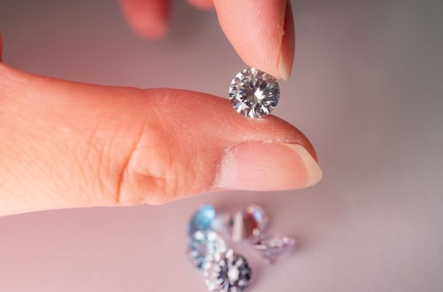 woman holding round diamond
